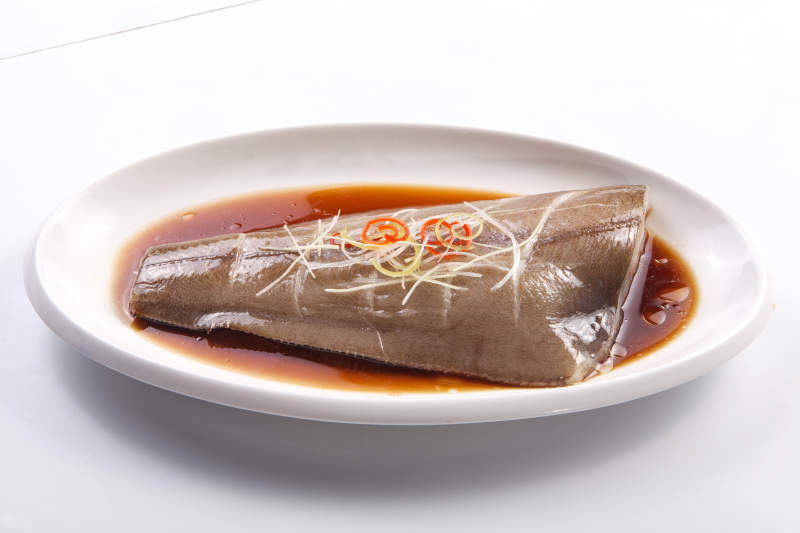 白色瓷盘装的浇汁清蒸鲽鱼尾