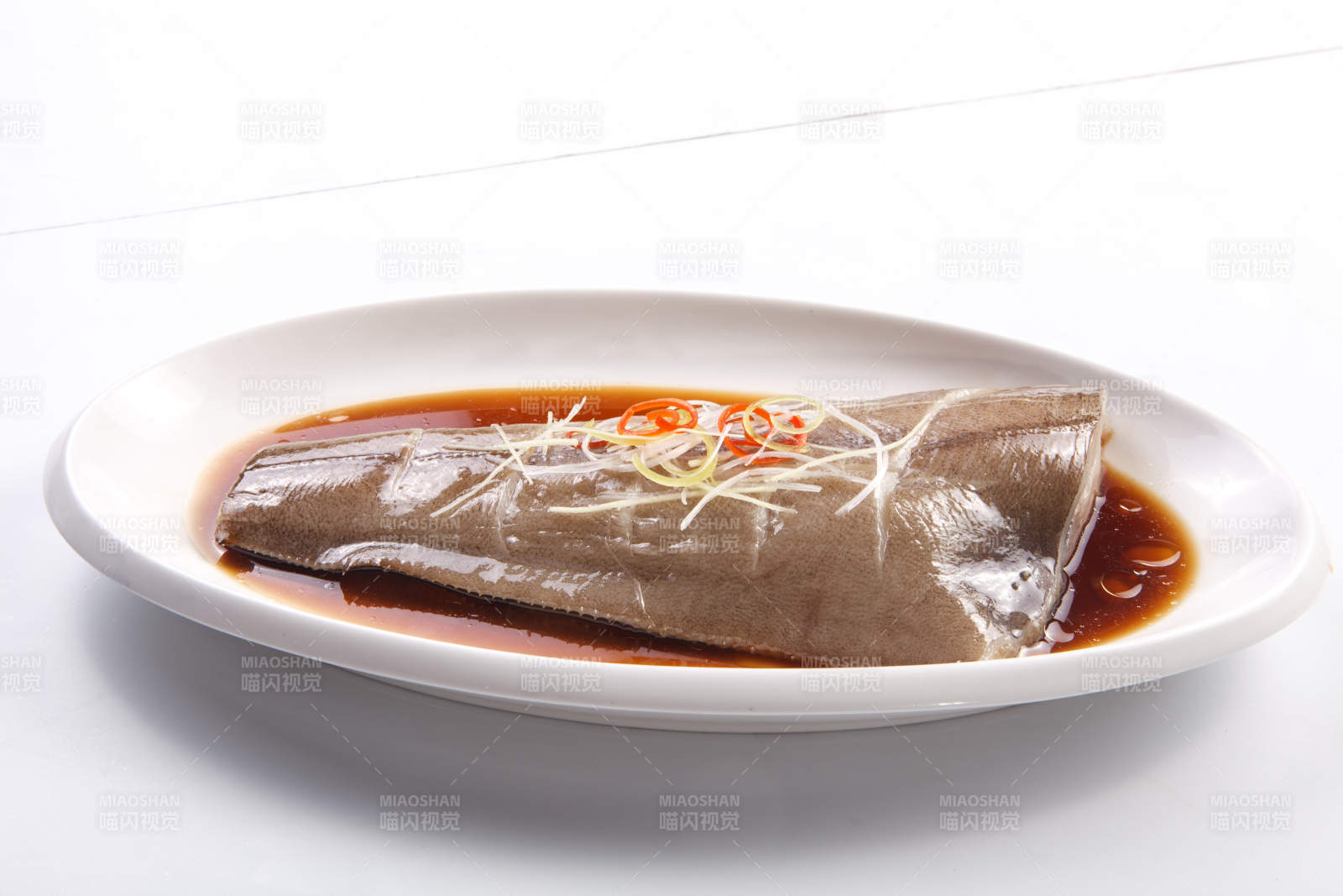 白色瓷盘装的浇汁清蒸鲽鱼尾