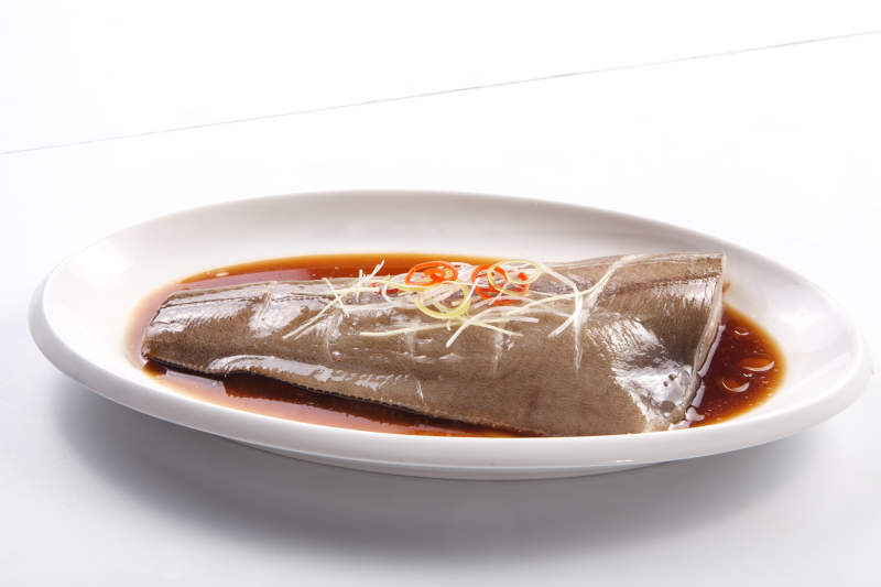 白色瓷盘装的浇汁清蒸鲽鱼尾