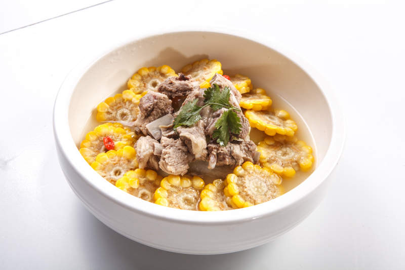 白色瓷盘装的清汤玉米炖猪排