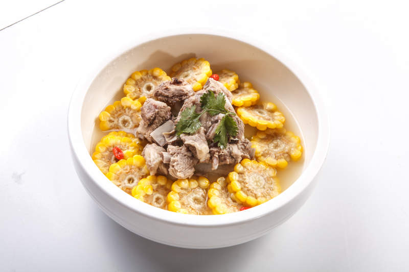 白色瓷盘装的清汤玉米炖猪排