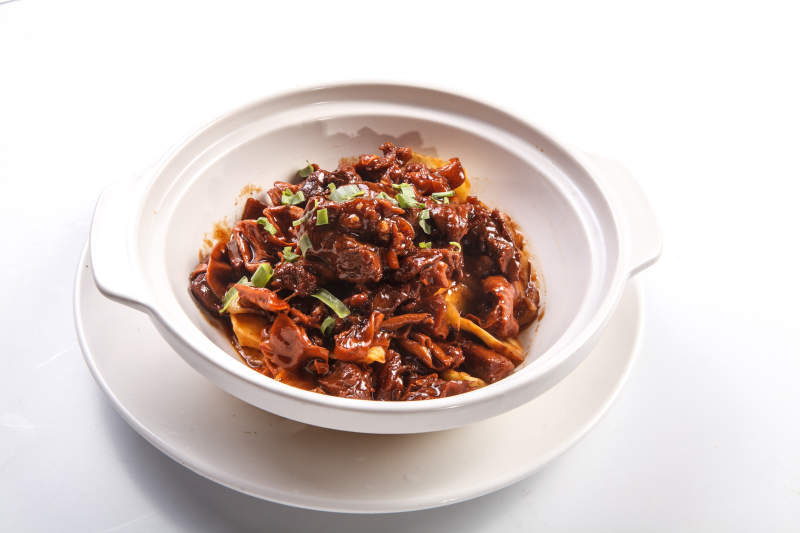 白背景上砂锅酱焖土豆烧牛腩