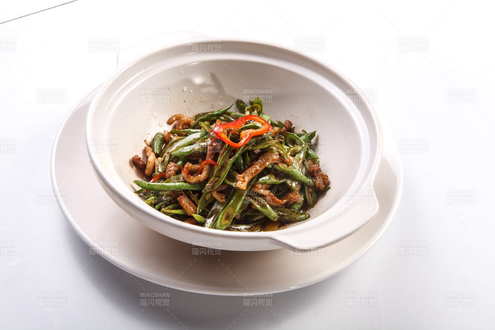 白色背景上的砂鍋醬爆豆角肉絲