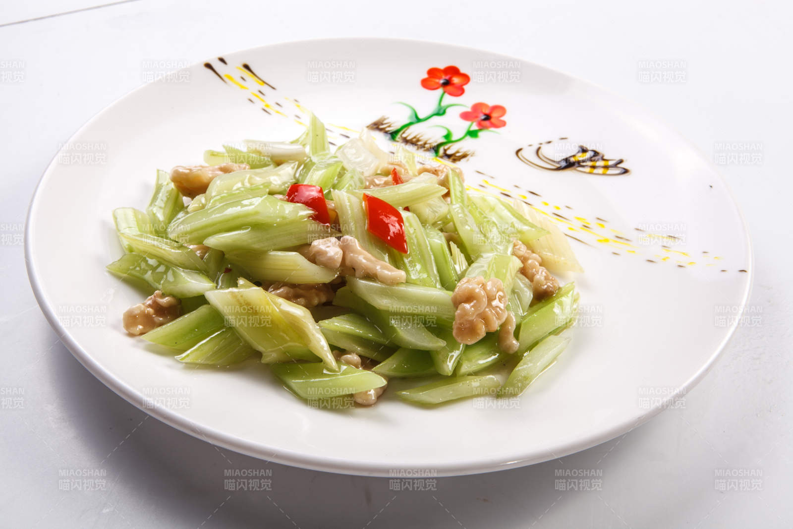 白色瓷盘装的西芹炒桃仁-摄影图