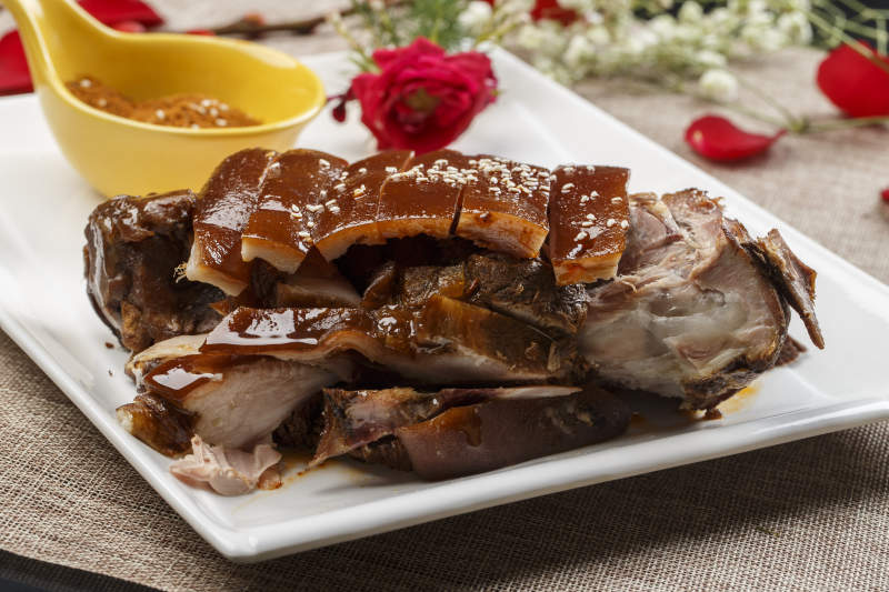 白色瓷盘装的脆皮烤猪肘