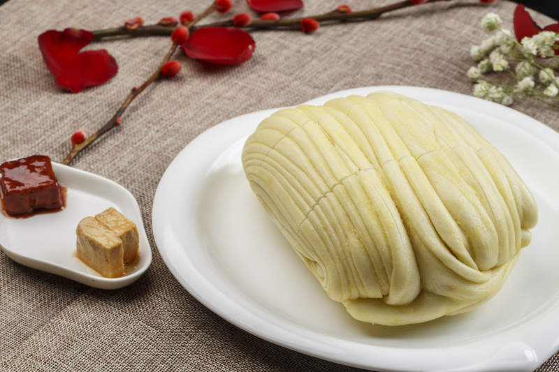 白色瓷盘装的现蒸麻油大花卷