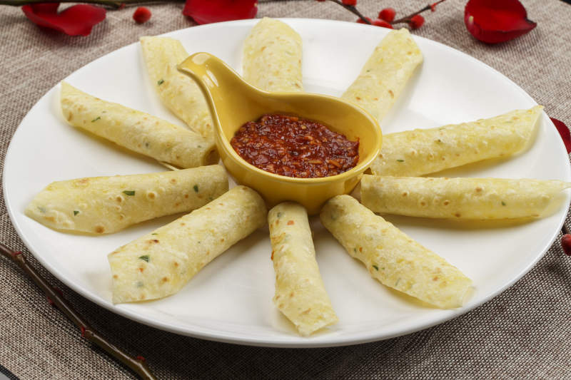 白色瓷盘装的蘸酱玉米饼