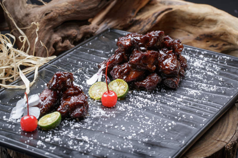 蜜汁叉烧小排骨摆放在樟木砧板上