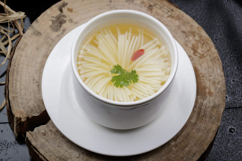 白色瓷汤盅装的菊花豆腐汤