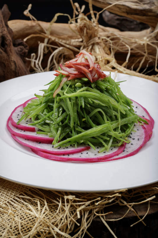 圆形瓷盘装的火龙果青瓜苗摆放在麻布垫子上