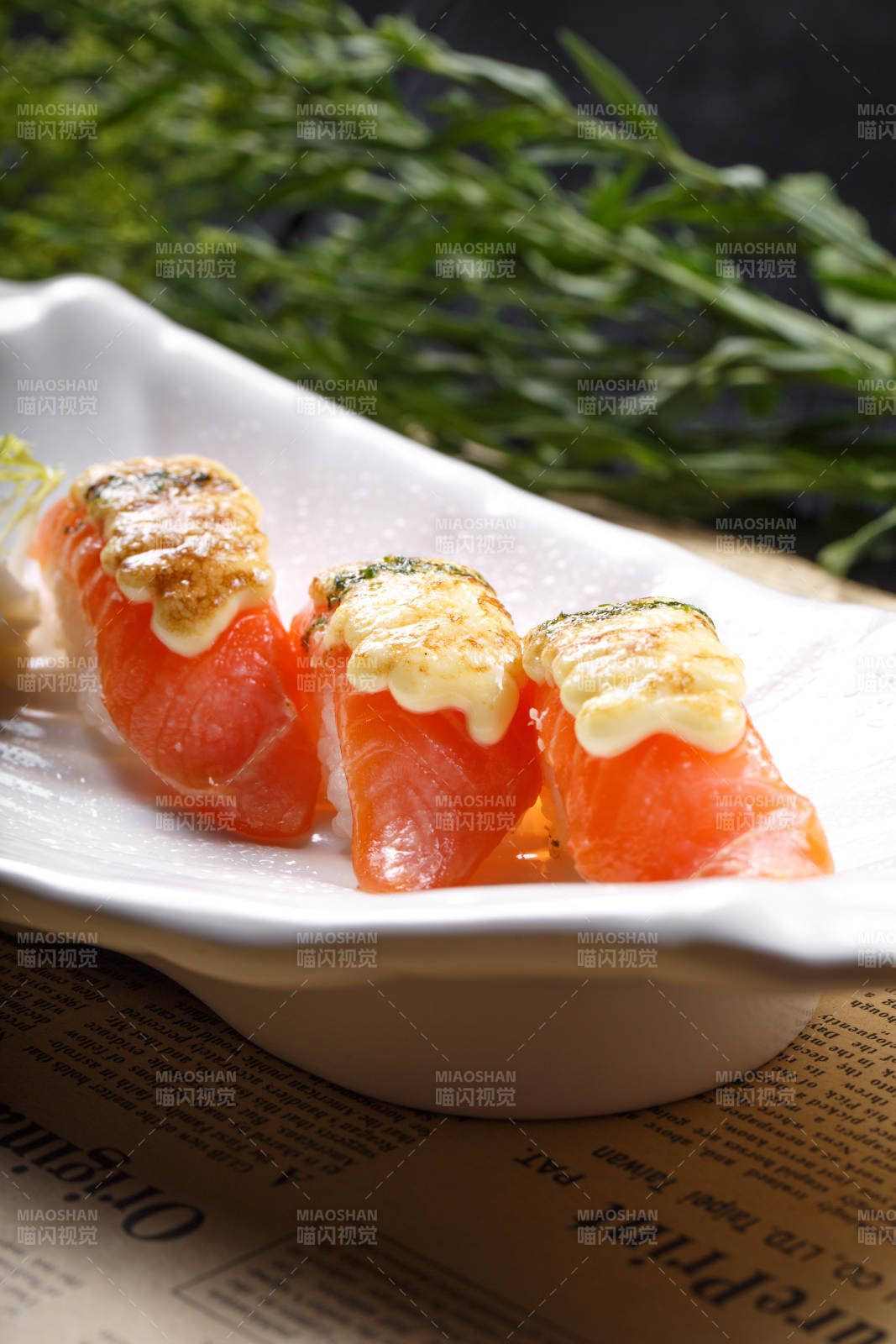 芝士焗三文魚手握壽司擺放在英文包裝紙上