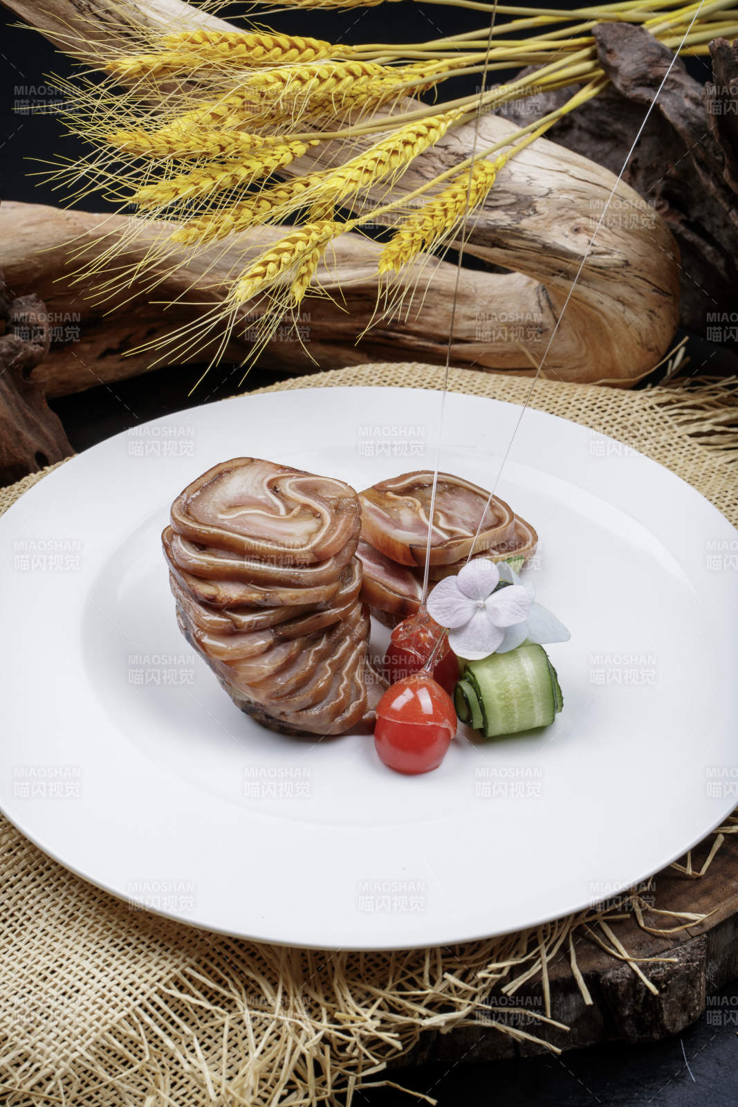 白色圆盘装的烟熏猪耳卷摆放在麻布垫子上