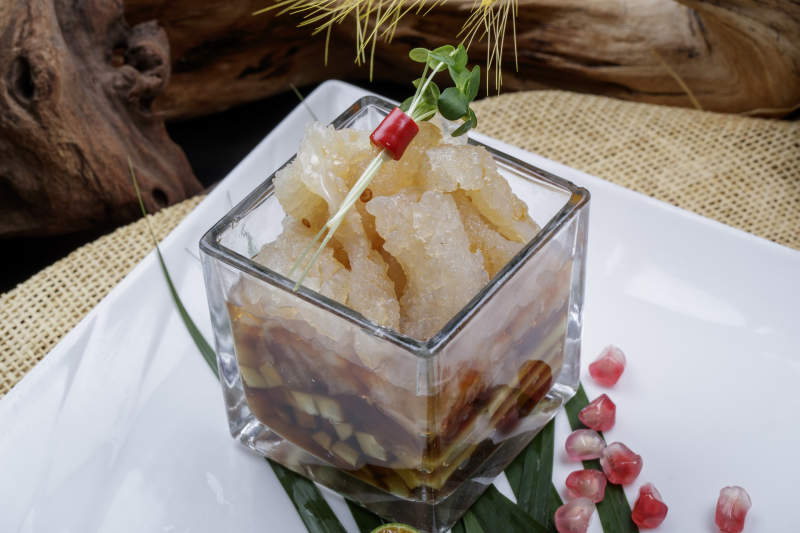 玻璃方盅装的老醋蛰头摆放在樟木砧板上