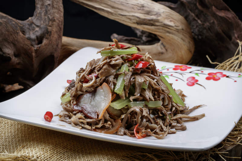 梅花图案白瓷盘装的五花肉烧鲜松蘑片