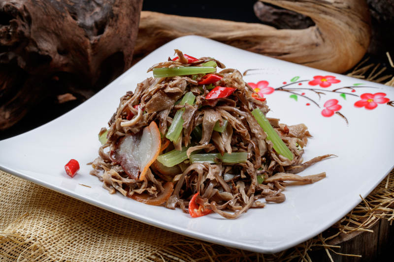 梅花图案白瓷盘装的五花肉烧鲜松蘑片