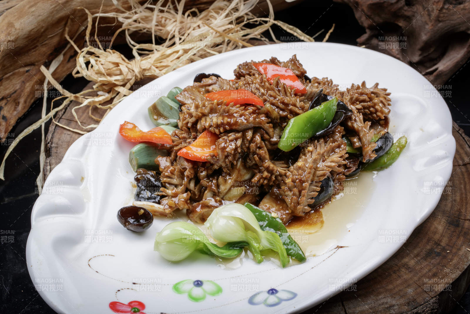 橢圓瓷盤裝的臘八蒜炒腰花擺放在樟木砧板上