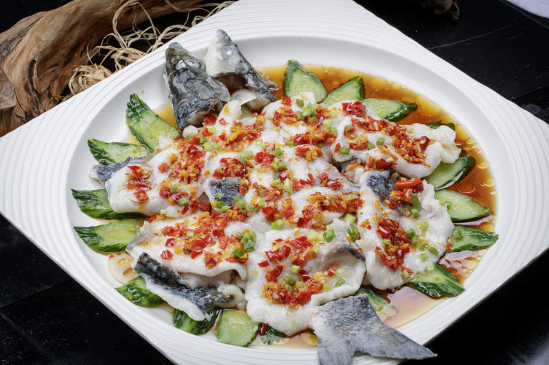 清蒸剁椒海梭鱼摆放在黑色背景上