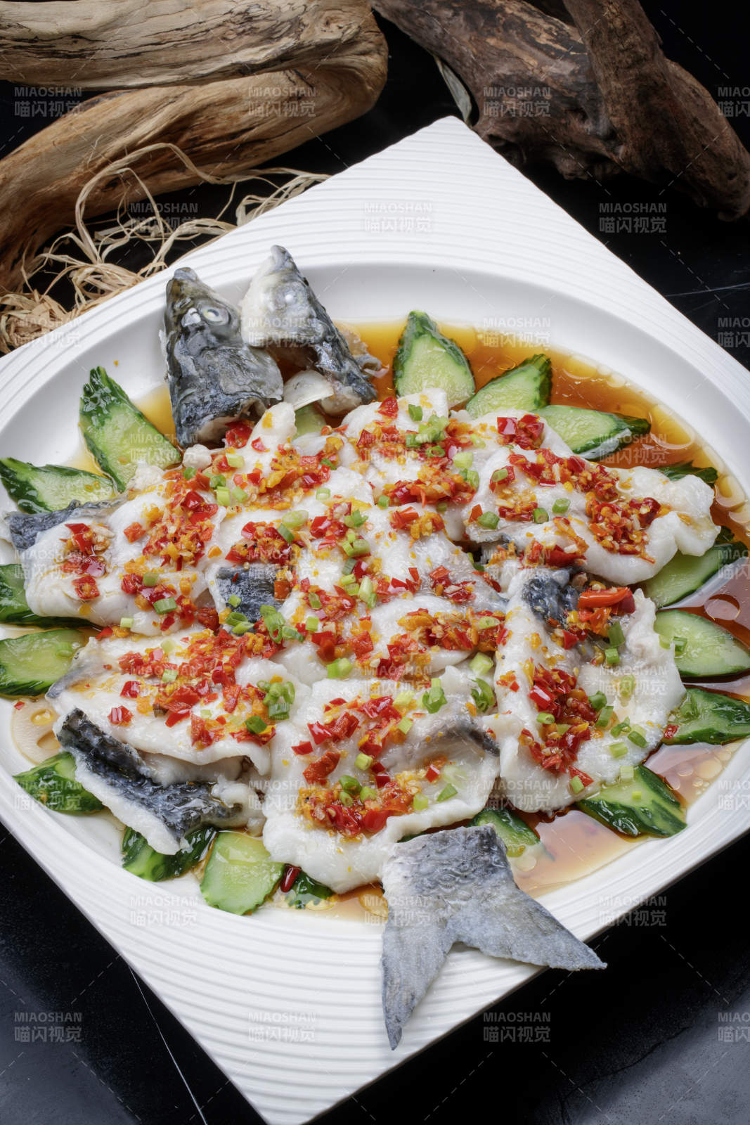 清蒸剁椒海梭鱼摆放在黑色背景上