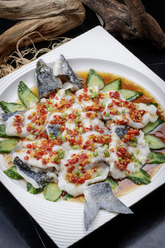 清蒸剁椒海梭鱼摆放在黑色背景上