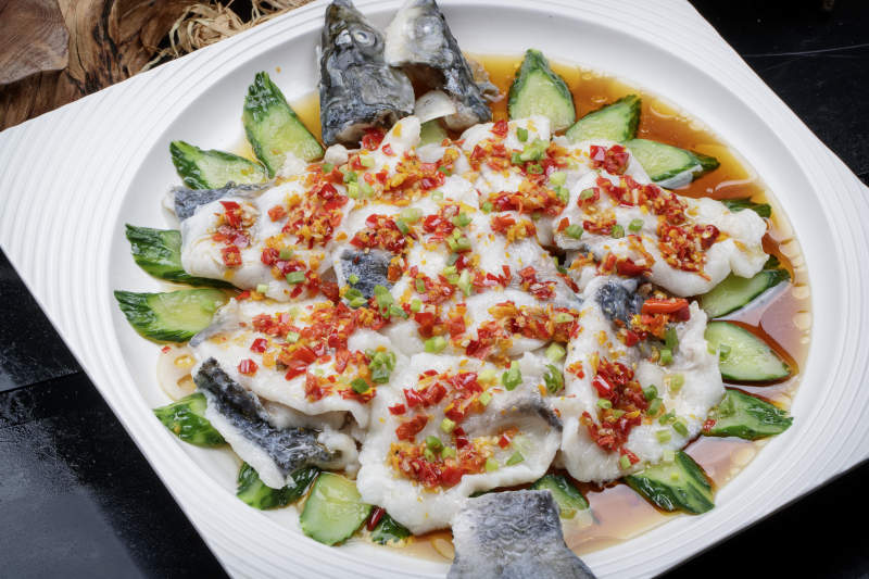 清蒸剁椒海梭鱼摆放在黑色背景上