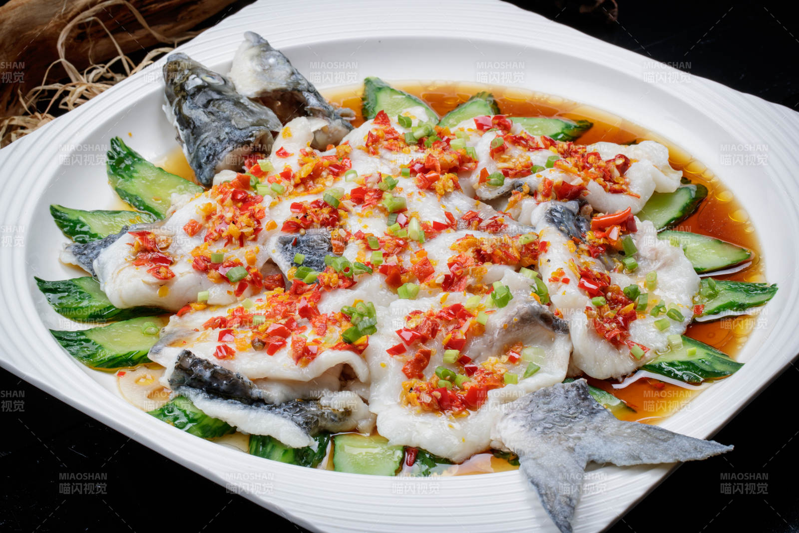 清蒸剁椒海梭鱼摆放在黑色背景上