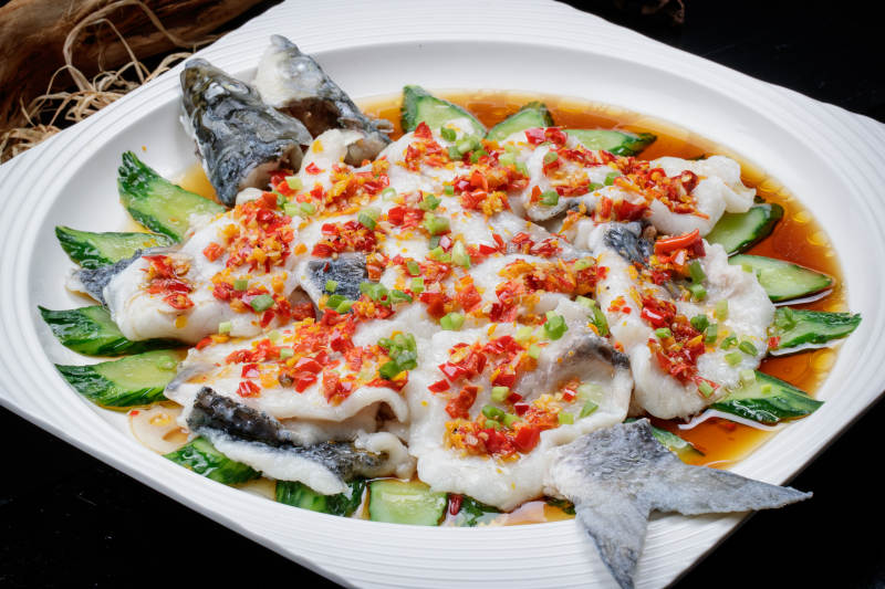 清蒸剁椒海梭鱼摆放在黑色背景上