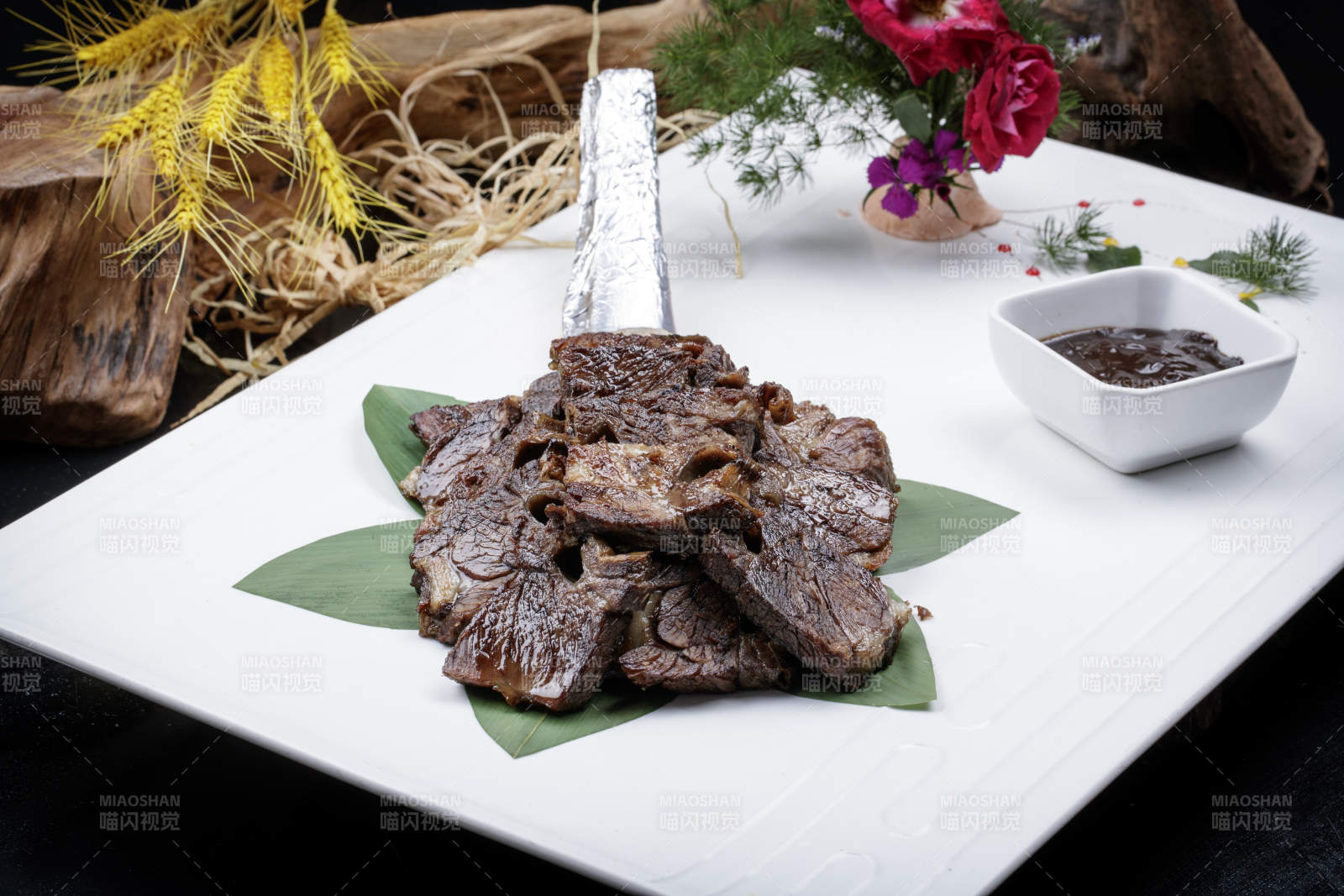 方形瓷盘装的炭烤牛肋排摆放在黑色背景上