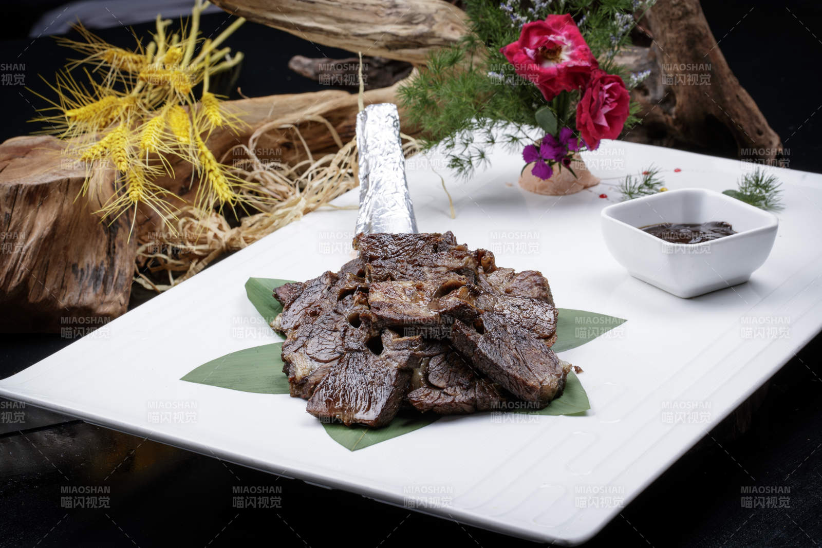 方形瓷盘装的炭烤牛肋排摆放在黑色背景上