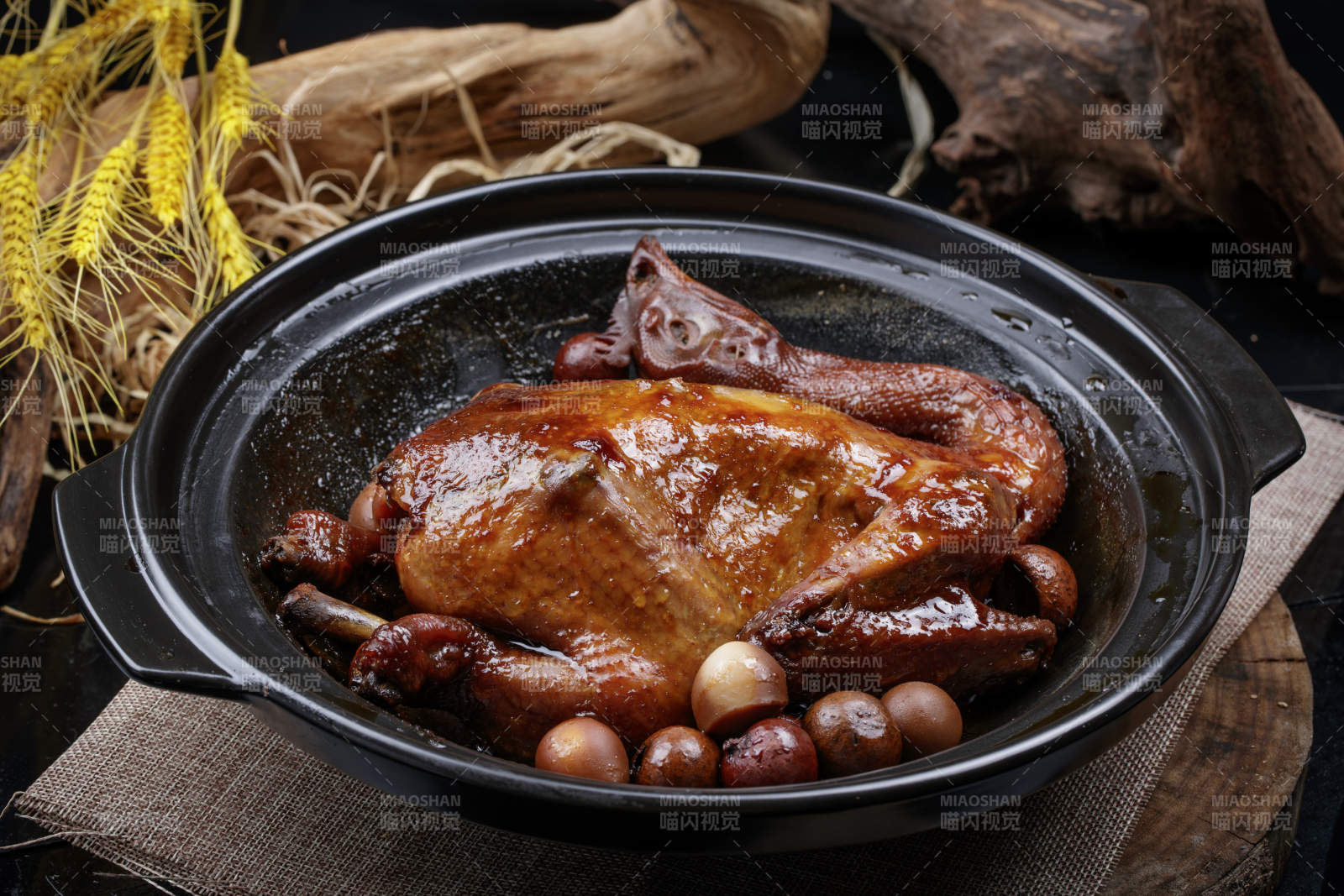 黑色砂锅装的生噘鸡煲摆放在幕布垫子上