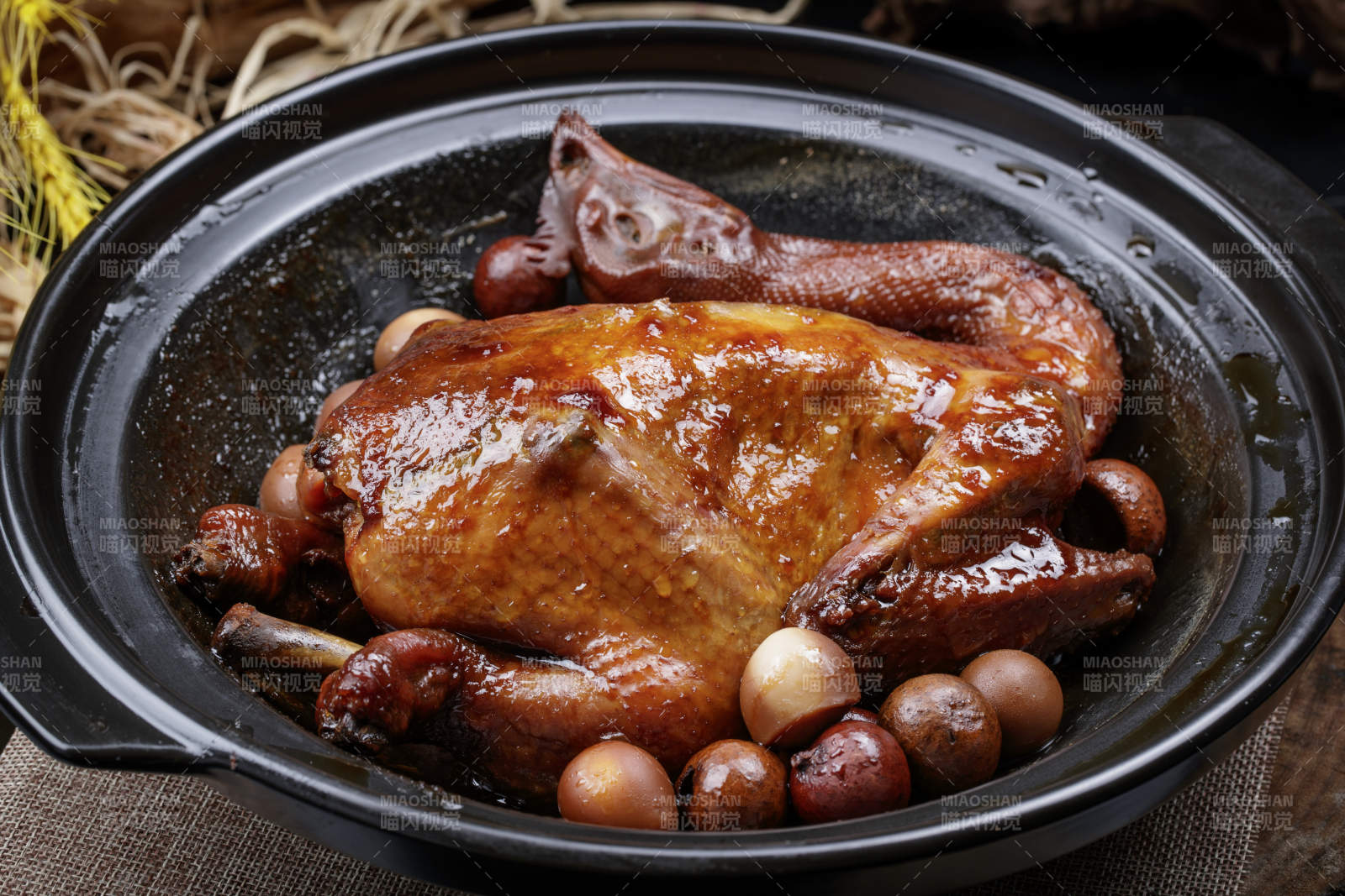 黑色砂锅装的生噘鸡煲摆放在幕布垫子上