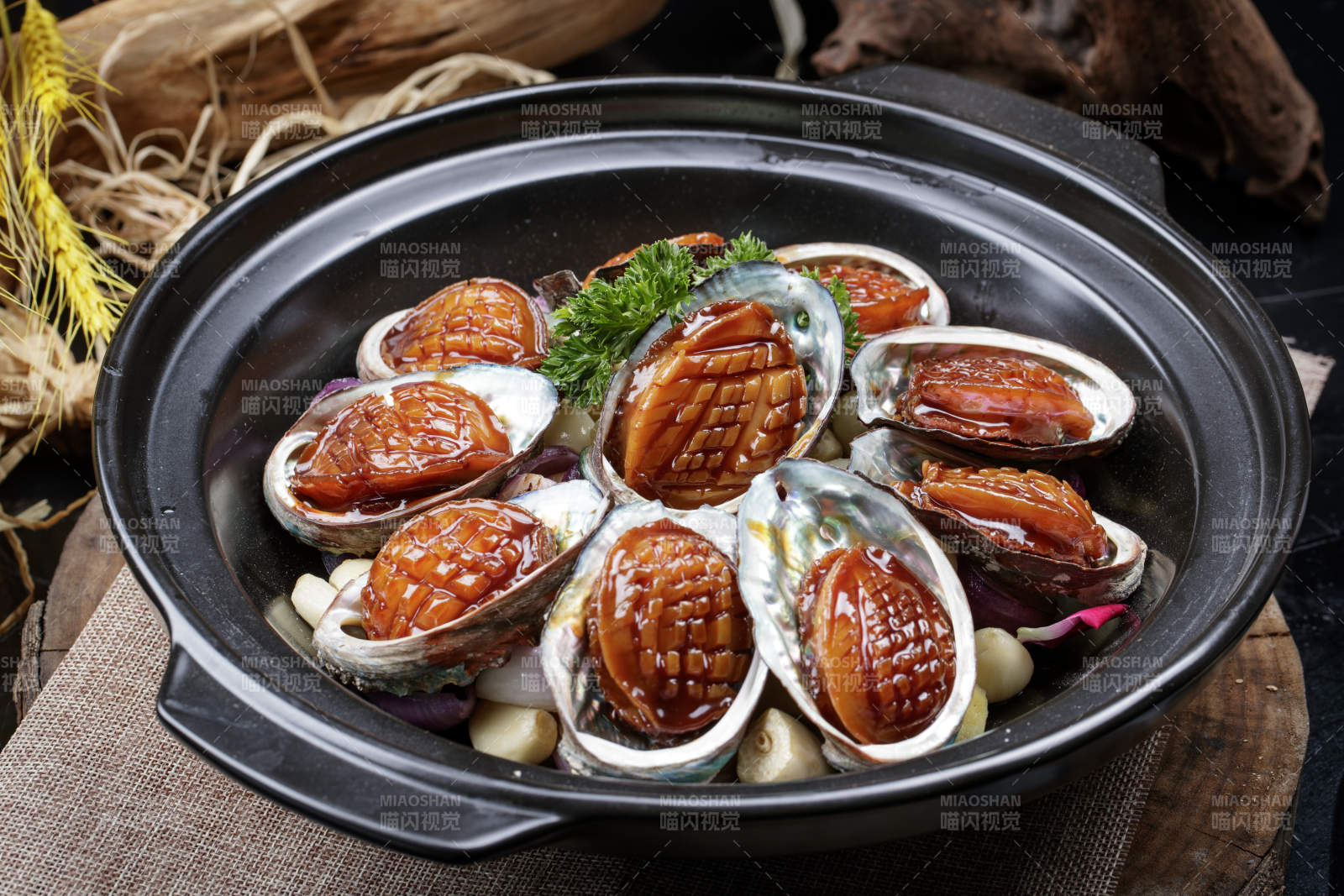 蒜焗砂锅鲜鲍鱼摆放在麻布垫子上