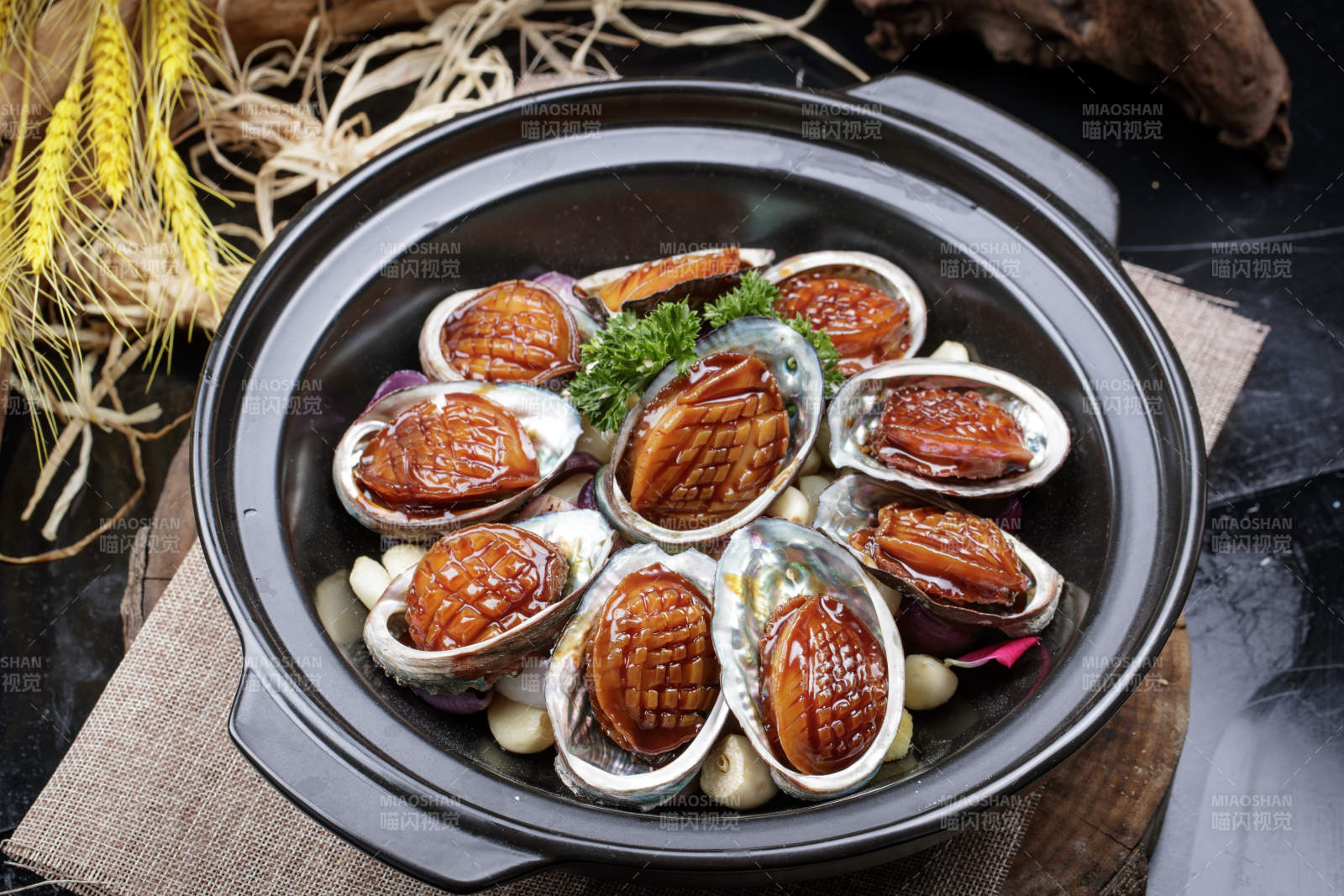 蒜焗砂锅鲜鲍鱼摆放在麻布垫子上