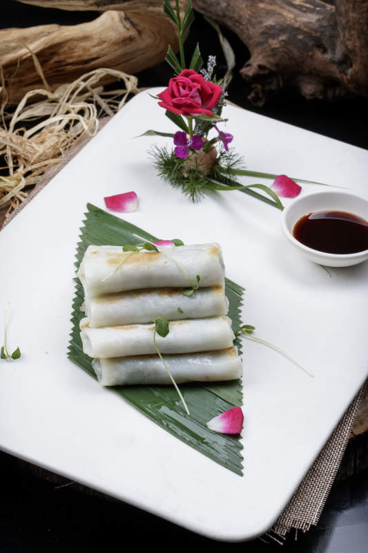 方形瓷盘装的河内肠粉摆放在黑色背景上