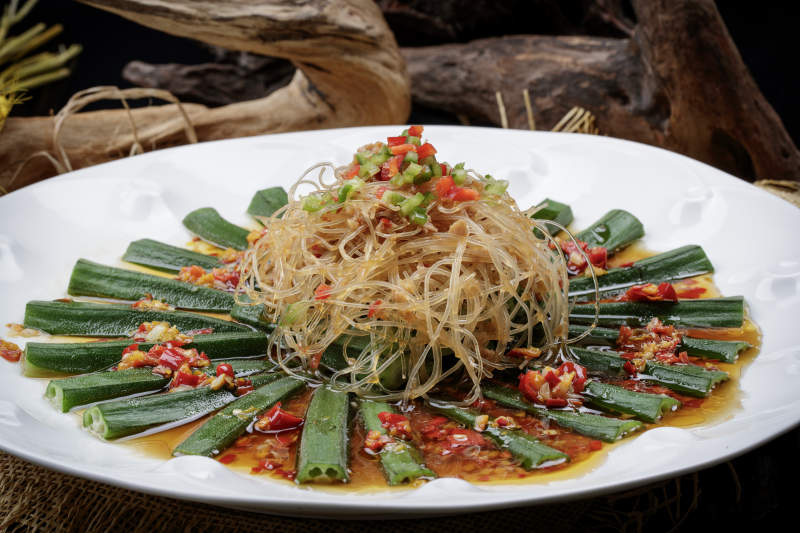 白色瓷盘装的蒜蓉粉丝蒸秋葵