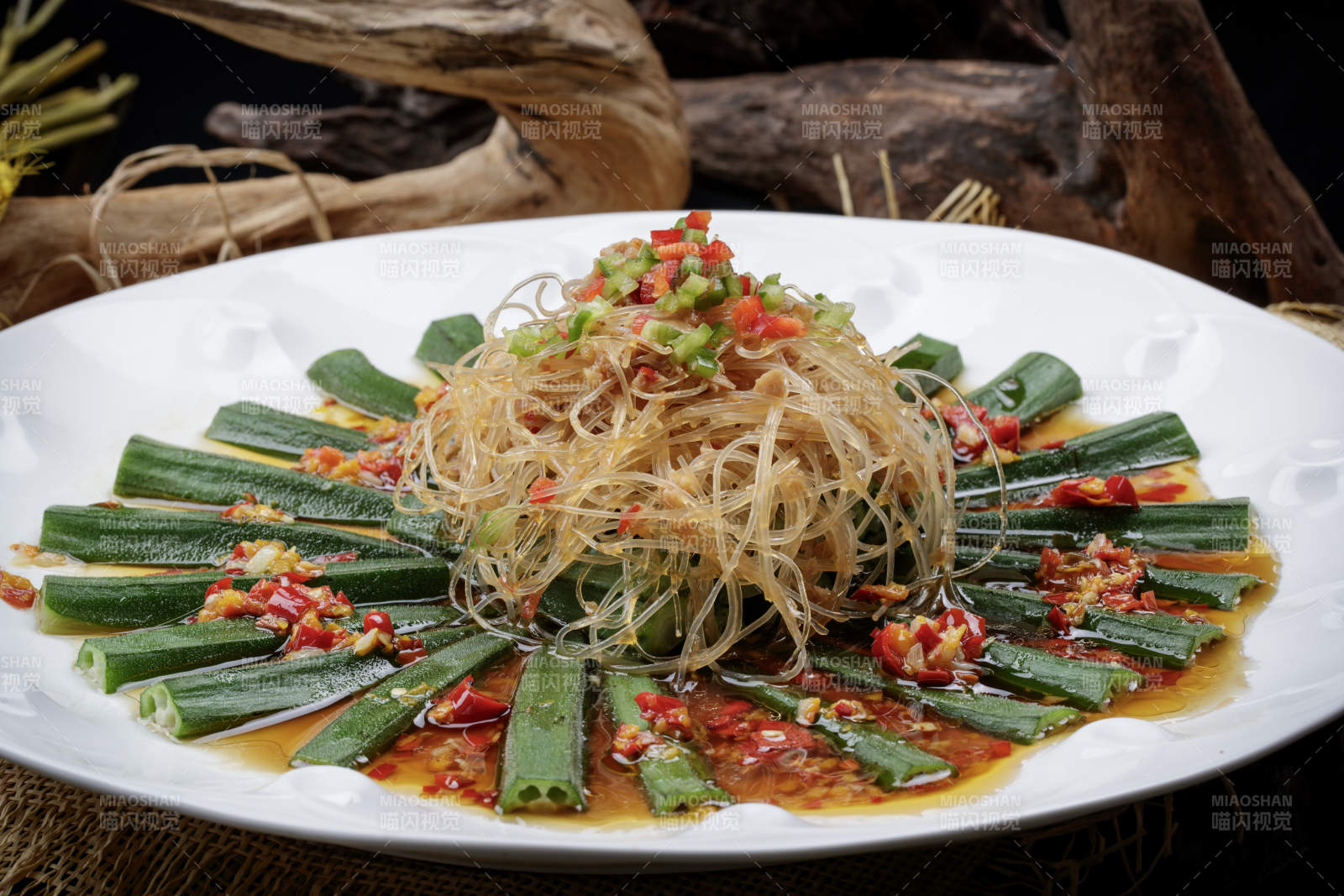 白色瓷盘装的蒜蓉粉丝蒸秋葵