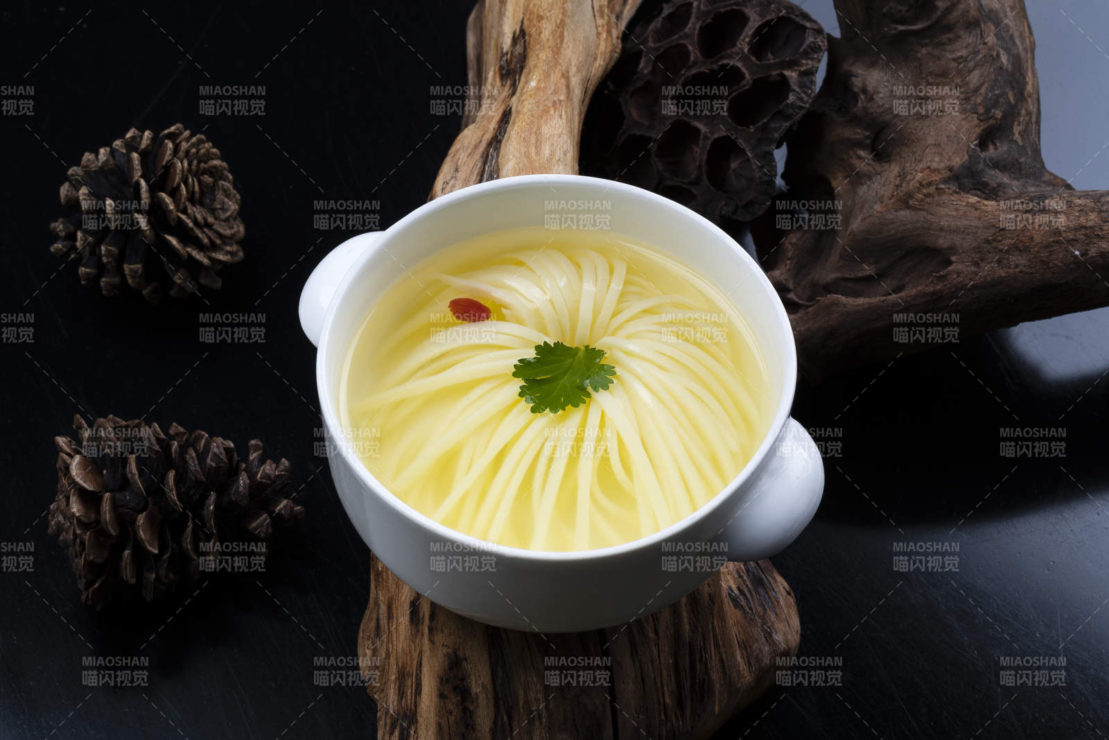 白色汤盅装的文菊豆腐养生汤摆放在崖柏根上