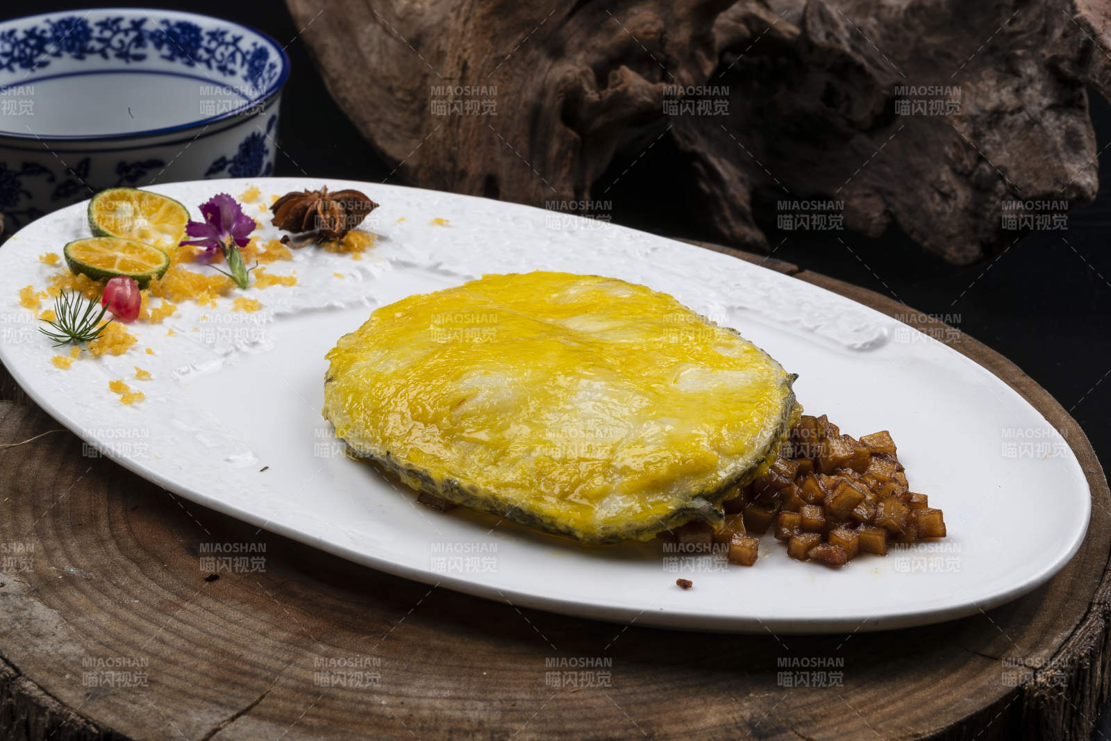 托圓瓷盤裝的香煎銀鱈魚擺放在樟木砧板上