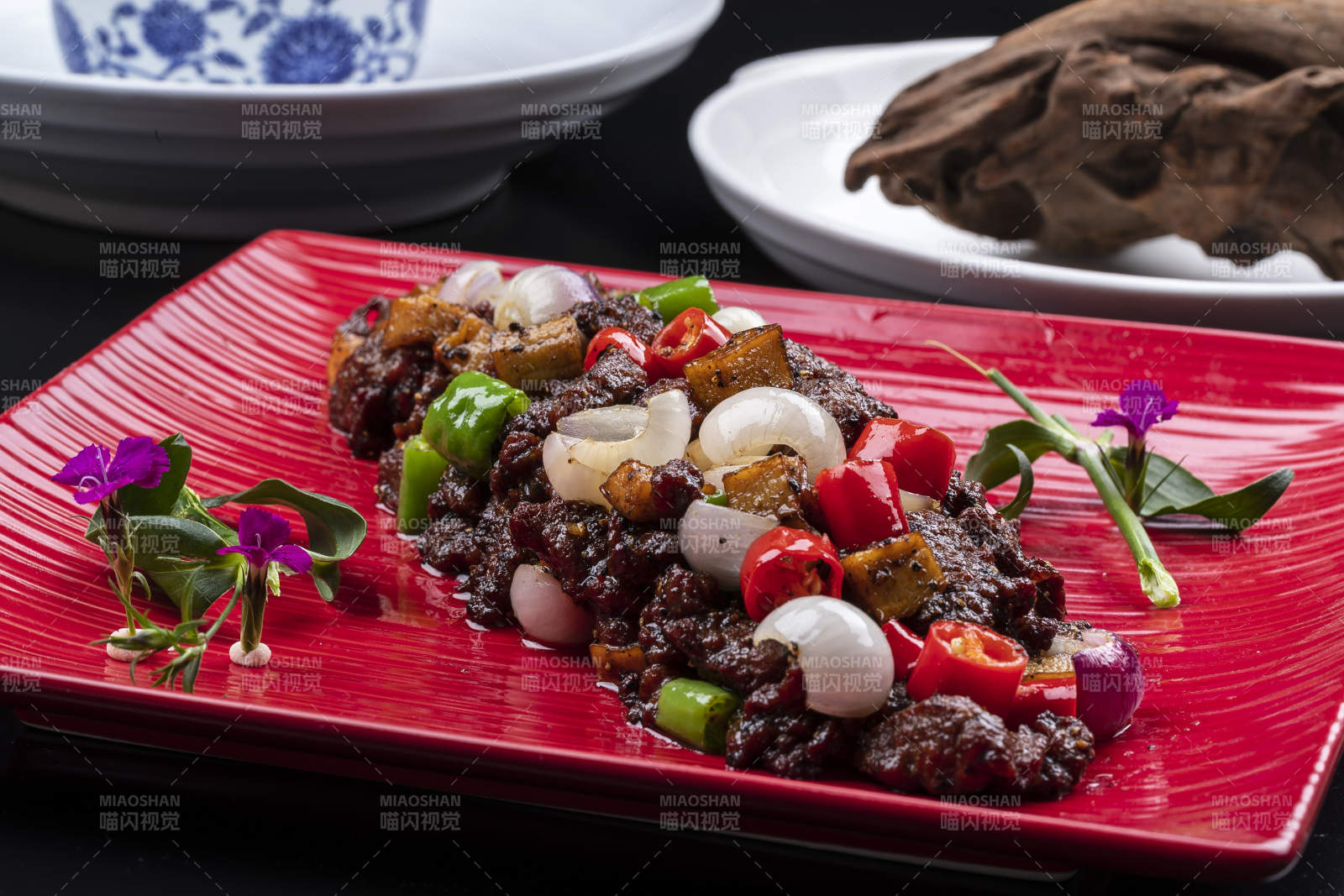 杭椒葱香牛仔粒摆放在黑色背景上