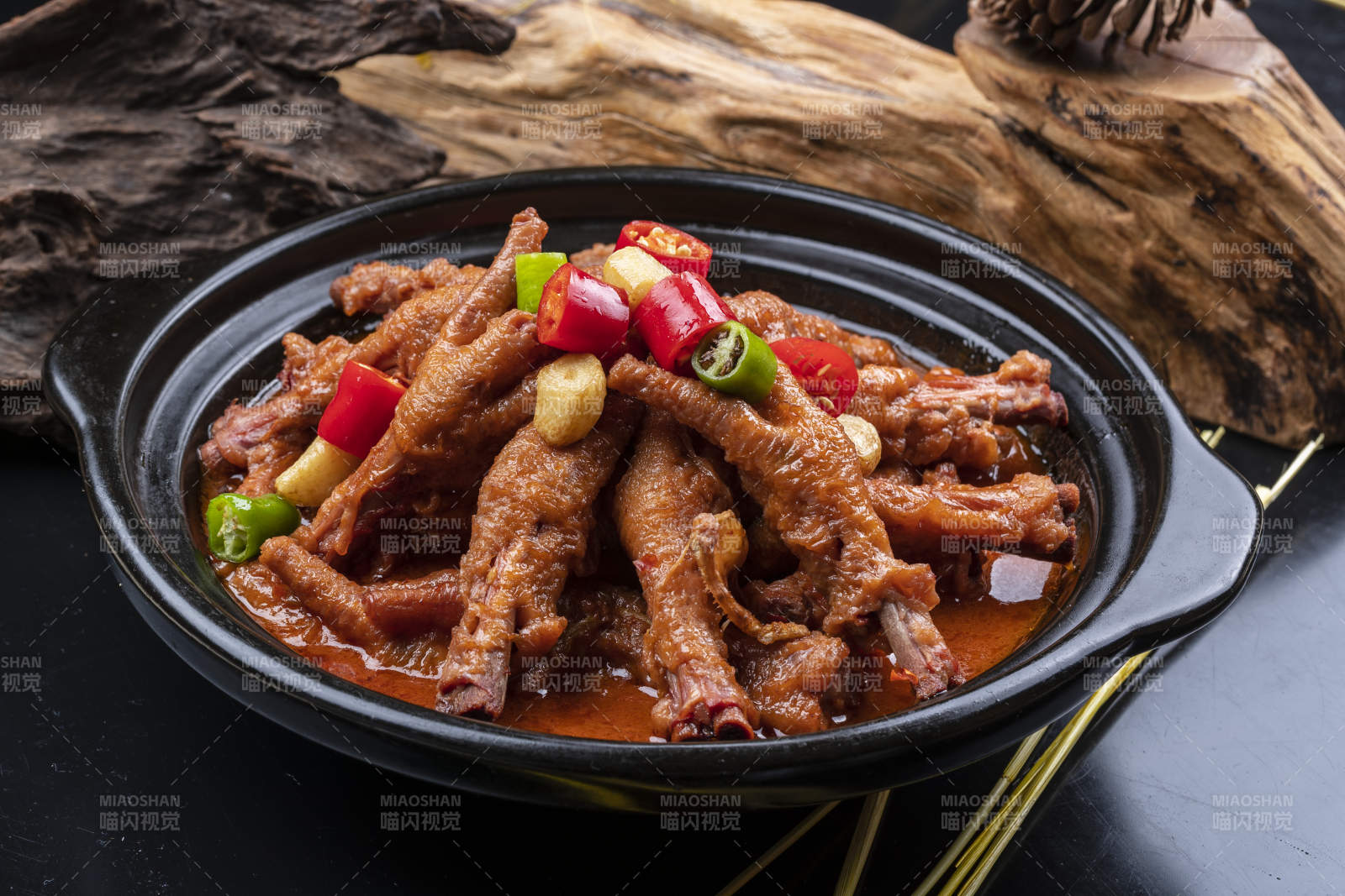蒜香砂锅煲凤爪摆放在黑色背景上