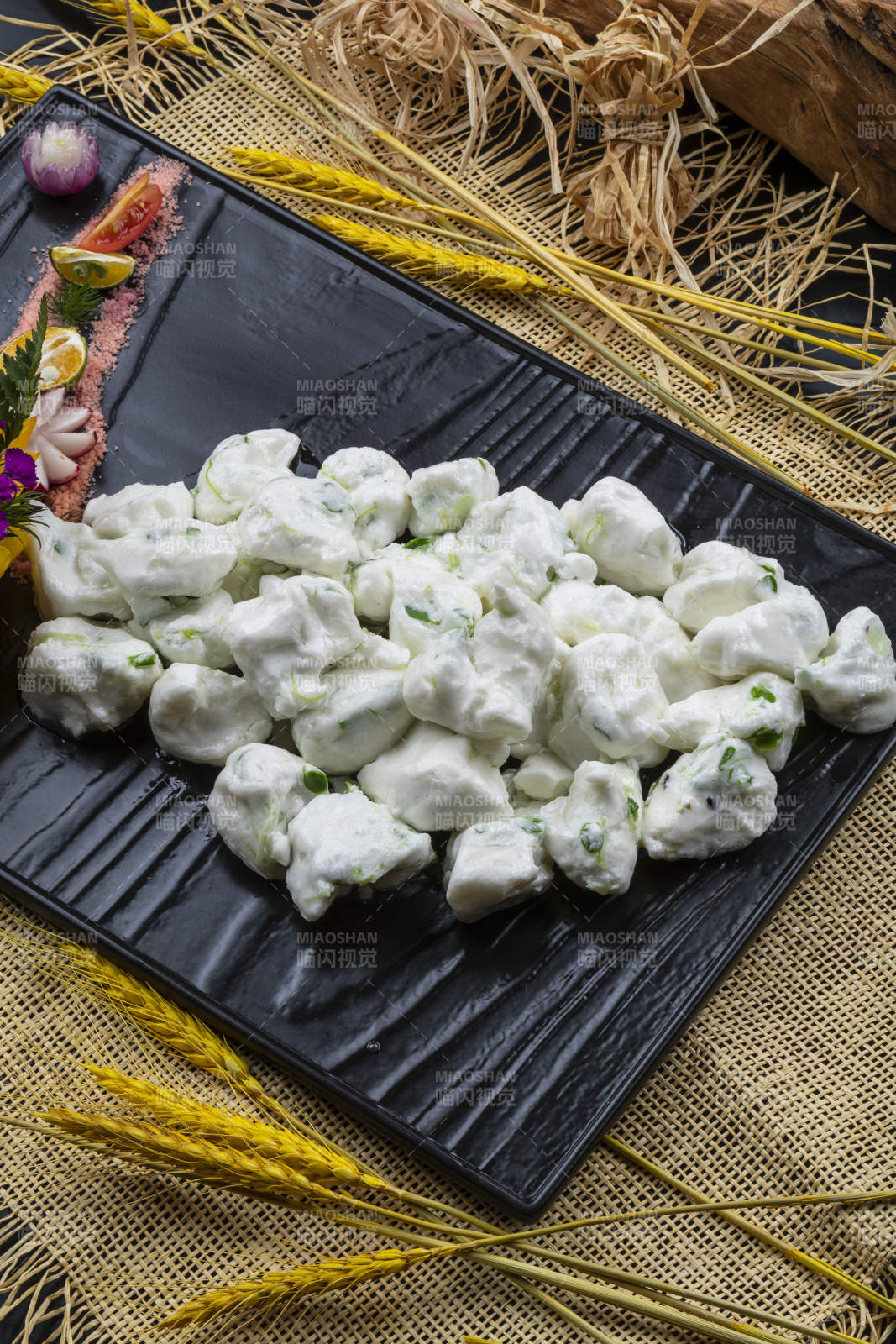 黑色石盤(pán)裝的香椿芽炒飛龍擺放在麻布?jí)|子上