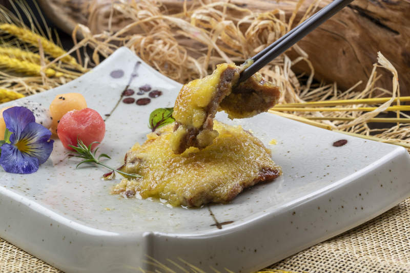 青色瓷盘装的黄金炸猪排摆放在麻布垫子上