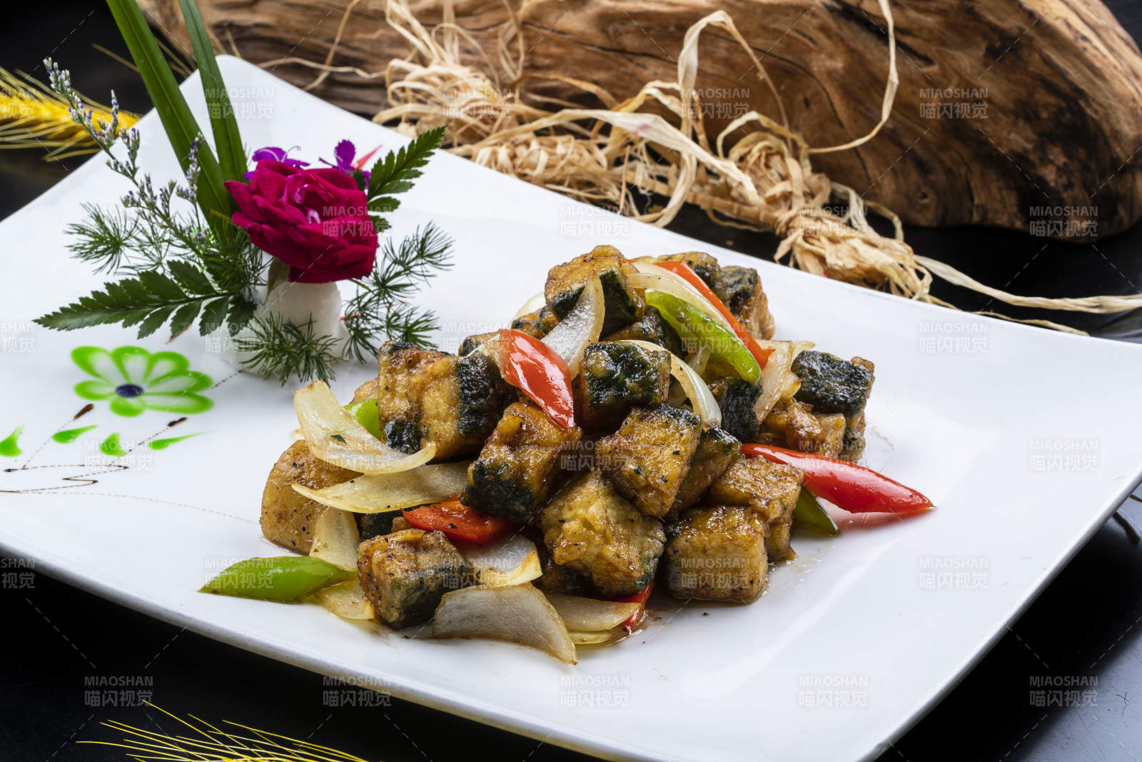 椒麻炸深海魚(yú)塊擺放在黑色背景上-攝影圖