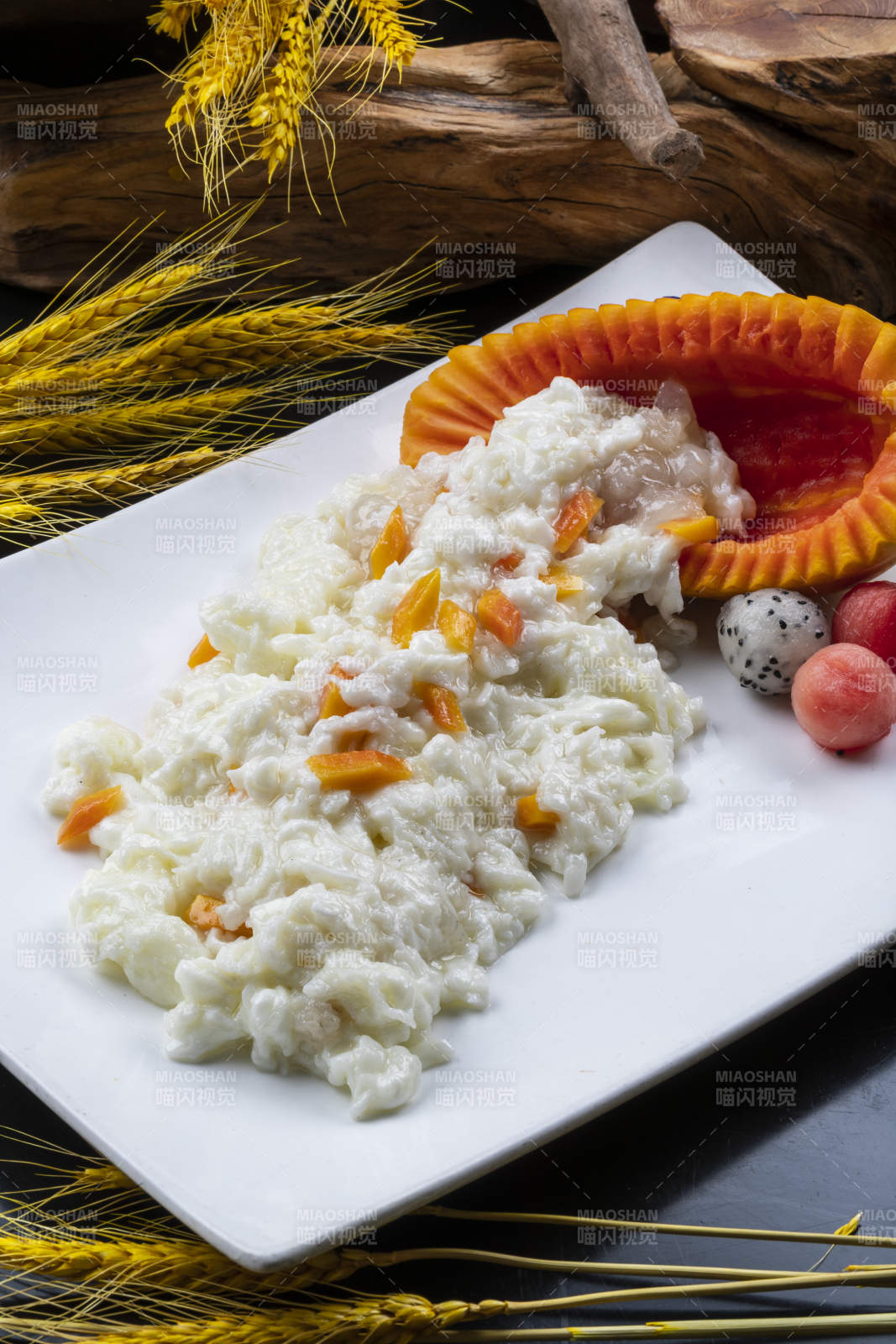長方形瓷盤裝的木瓜芙蓉蛋擺放在黑色背景上