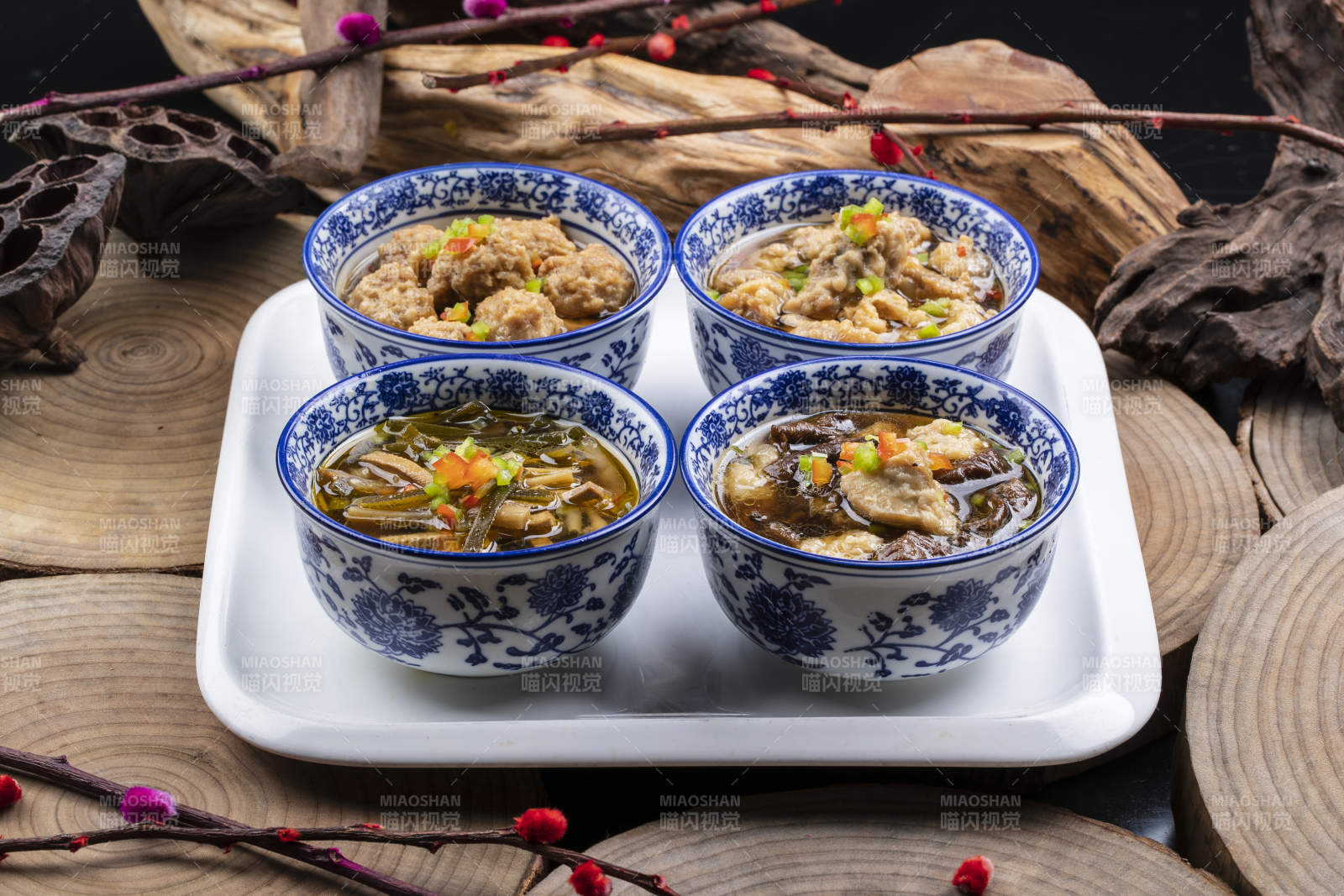 青花瓷碗装的传统四大碗摆放在樟木砧板上
