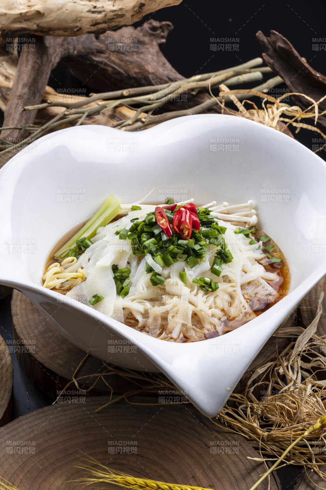 心型瓷盆装的晋味鸡汤凉皮摆放在樟木砧板上