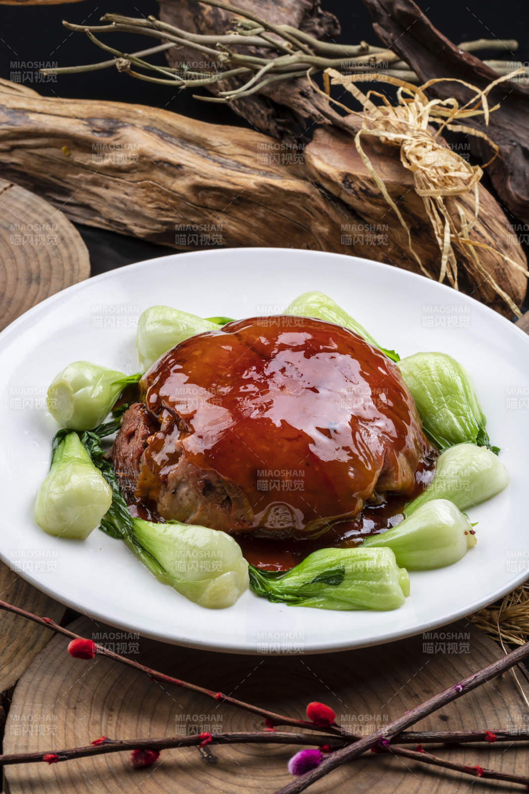 圓形瓷盤裝的紅燜扣肉擺放在樟木砧板上