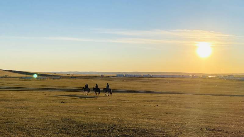 呼伦贝尔草原日落骑马图