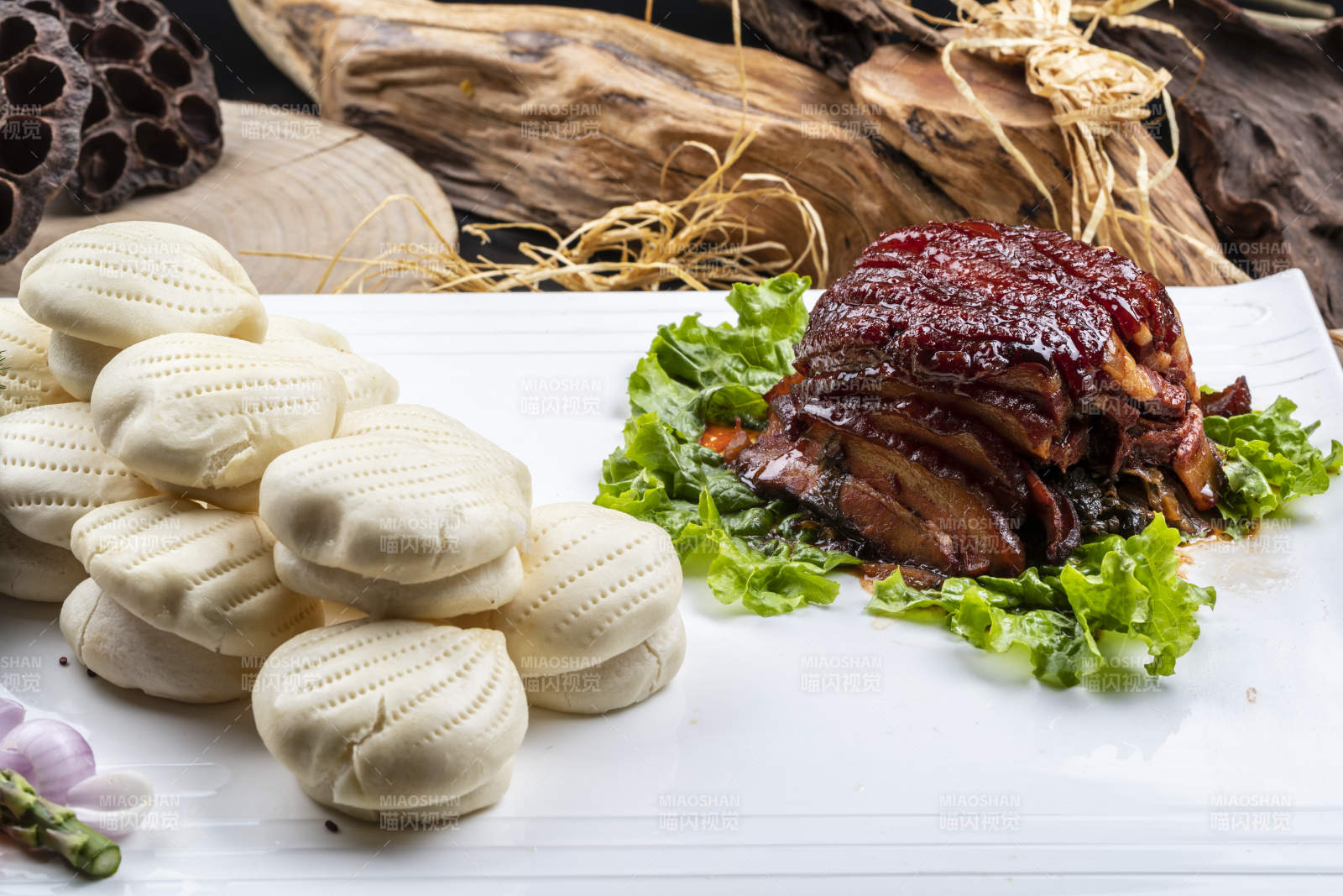 長方形瓷盤裝的花饃夾醬肉擺放在樟木砧板上