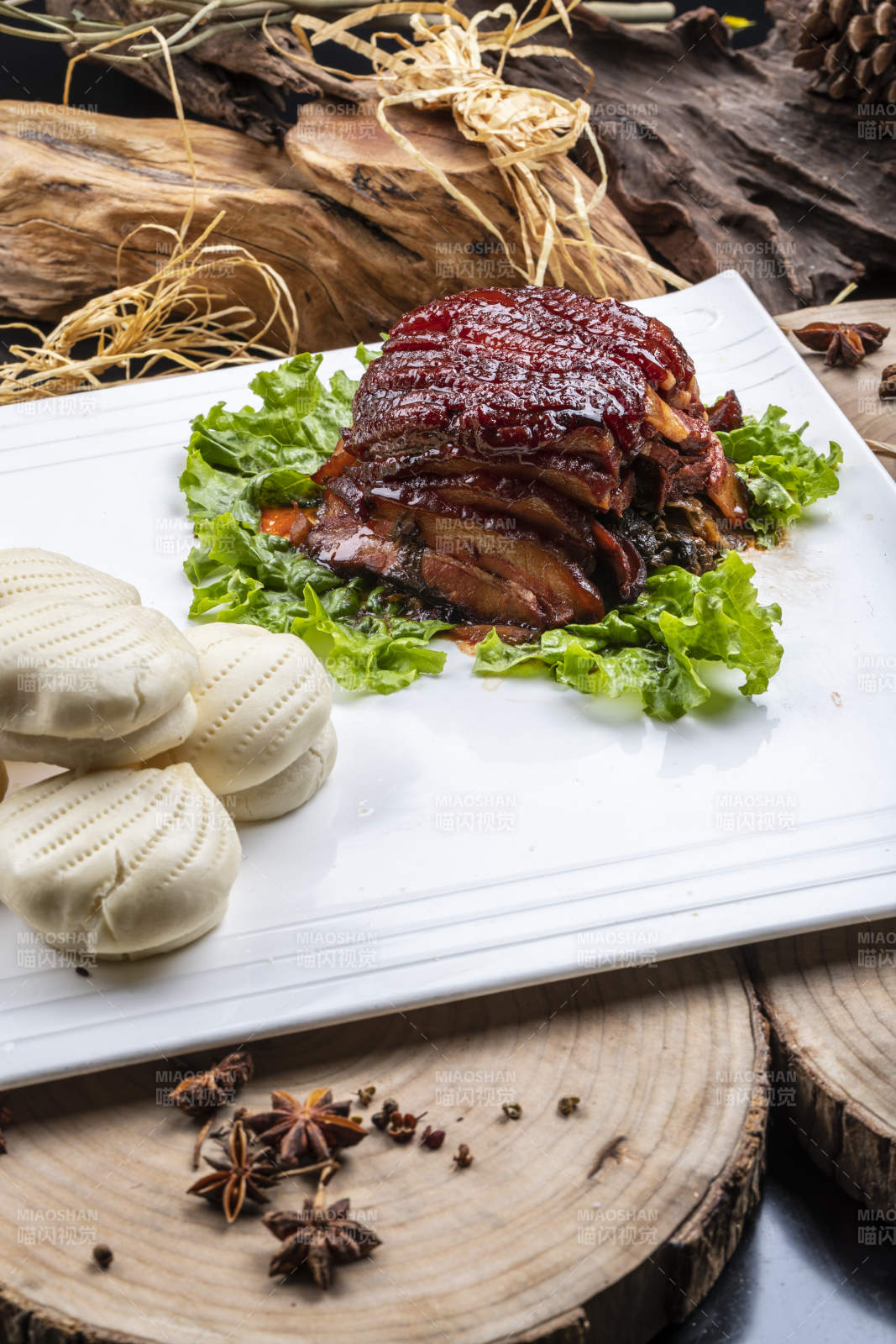 長方形瓷盤裝的花饃夾醬肉擺放在樟木砧板上