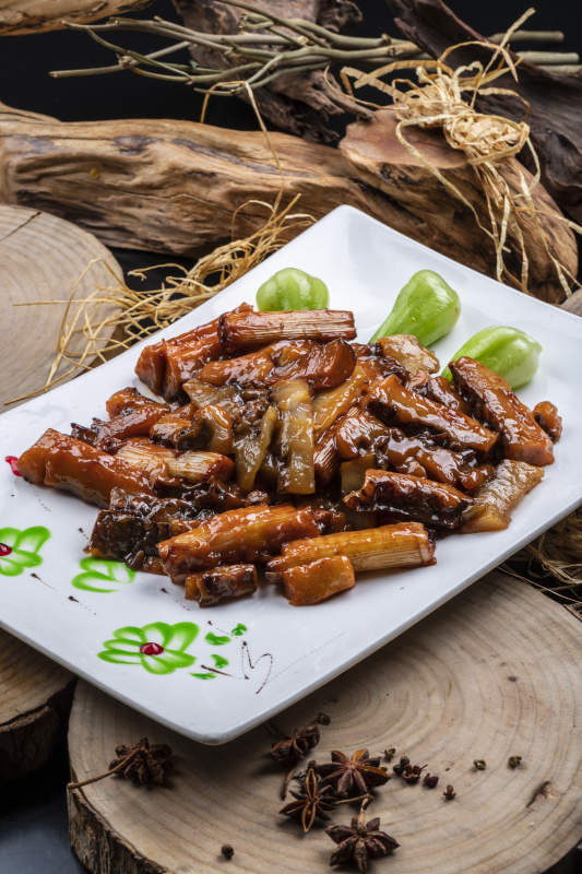 长方形花瓷盘装的葱烧皮参摆放在樟木砧板上